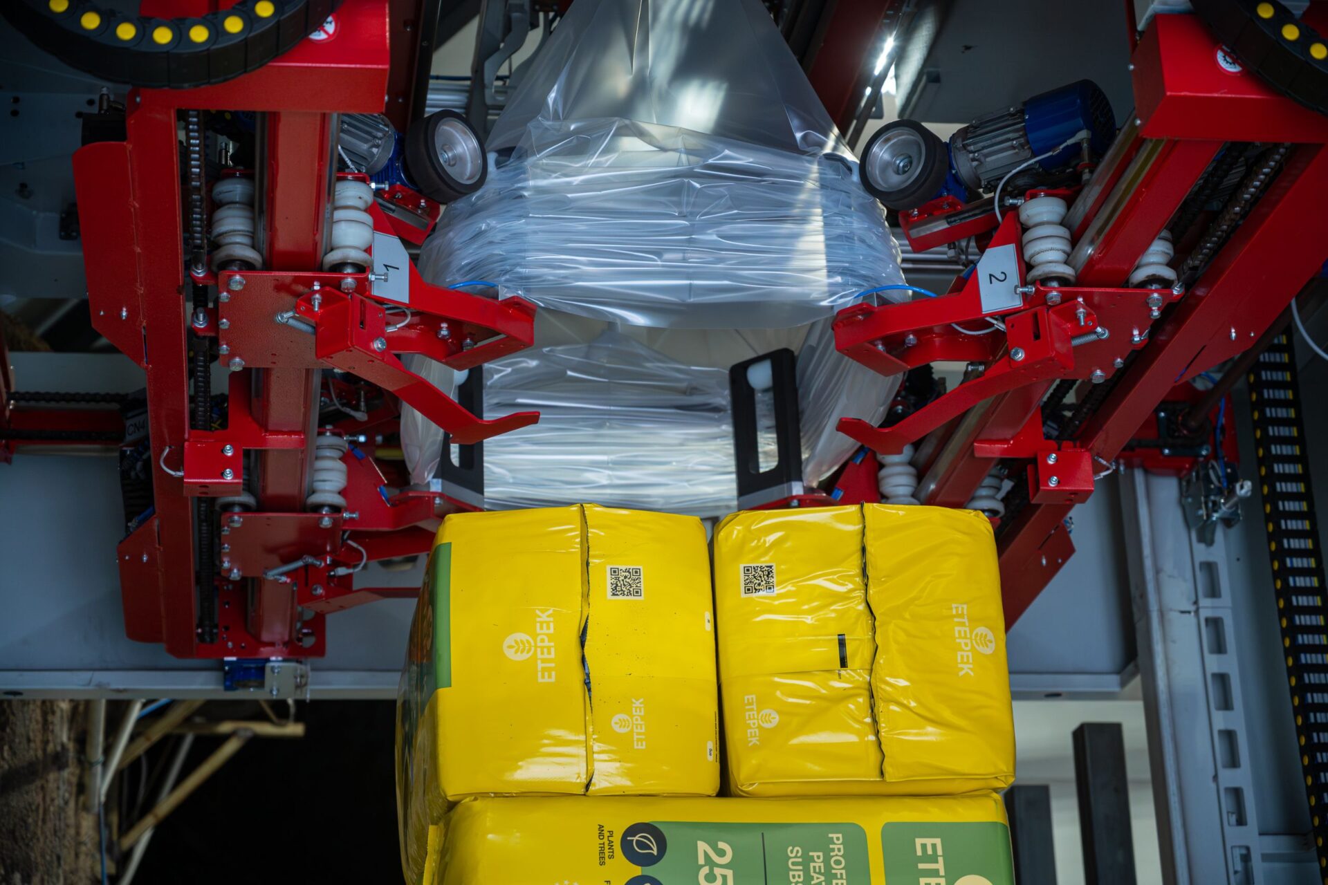 Automated packing system handling ETEPEK's yellow peat substrate bags, showcasing advanced packaging technology for professional-grade products.