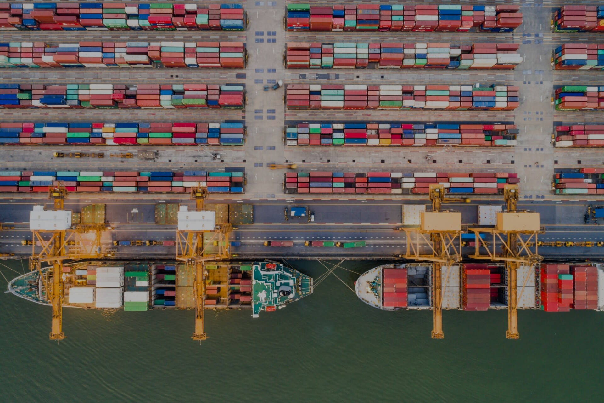 Aerial view of a busy cargo container port with ships docked for loading and unloading