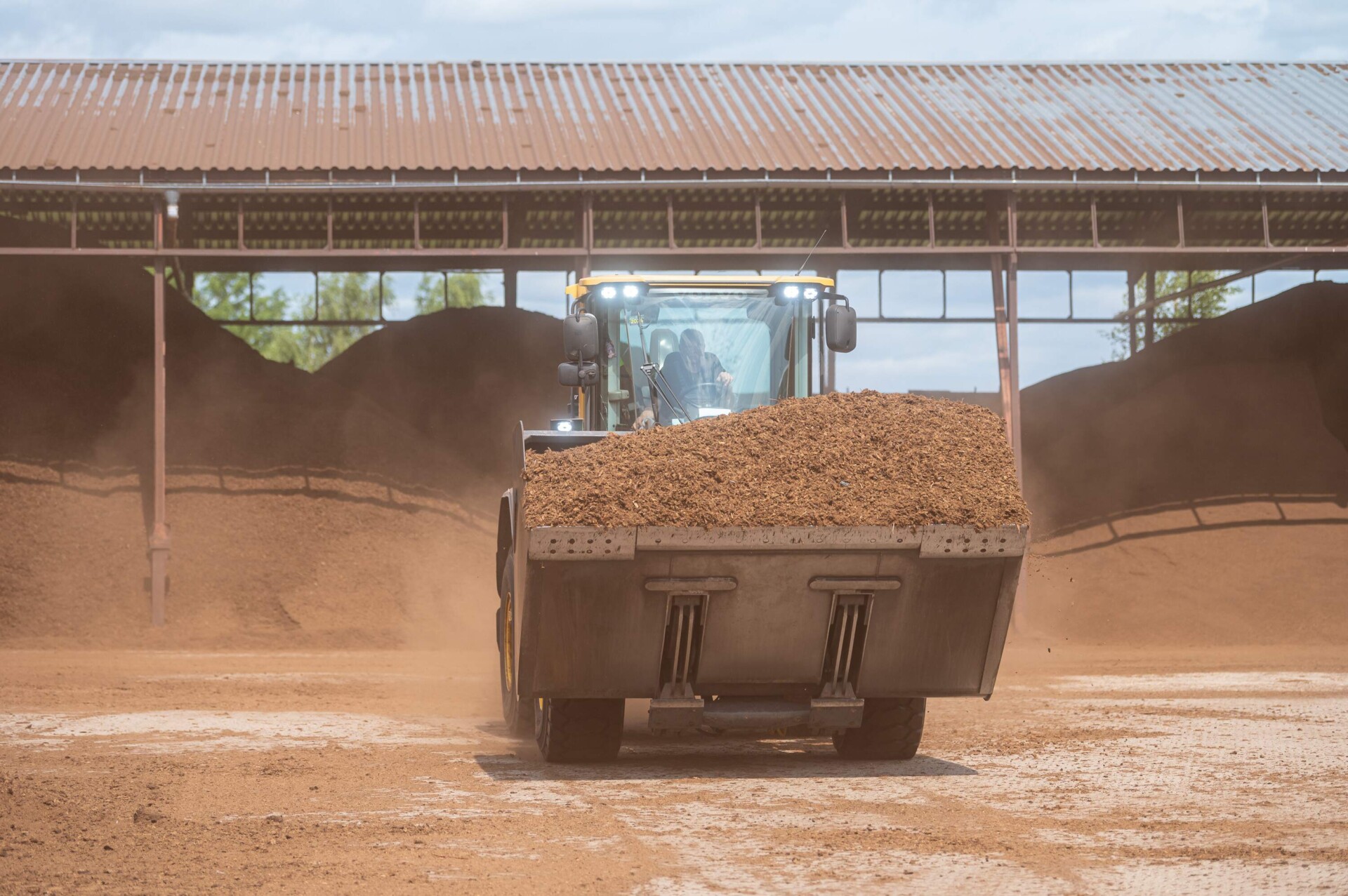 A large loader transporting high-quality peat moss in an industrial storage facility, demonstrating the efficient processing and supply of peat for horticultural use, etepek